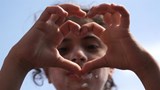 Having fled from Syria's conflict, a child refugee shows hope for peace in Al Jaleel refugee camp.